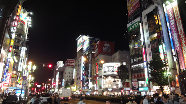 the streetscape is full of coloured lights and signs